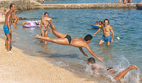 Left beach player jumping inward